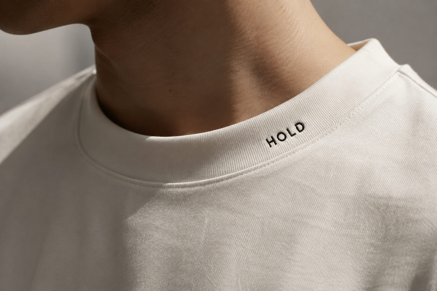 Close-up of a white HOLD T-shirt collar
